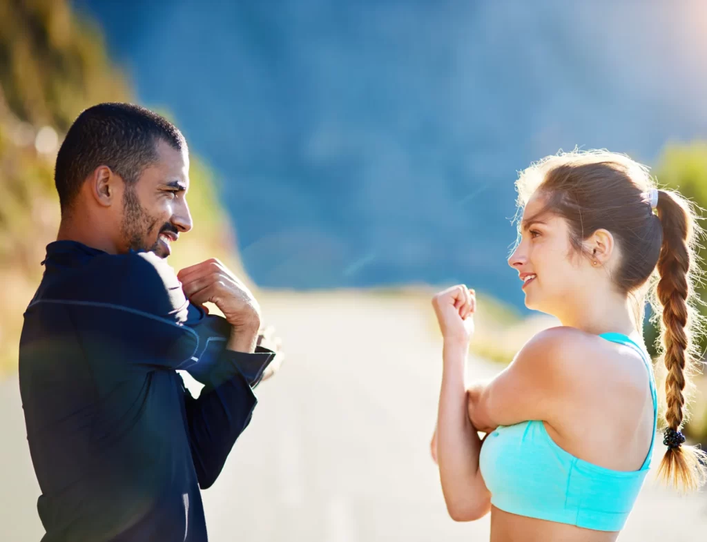 active couple stretching on a sunny day utc
