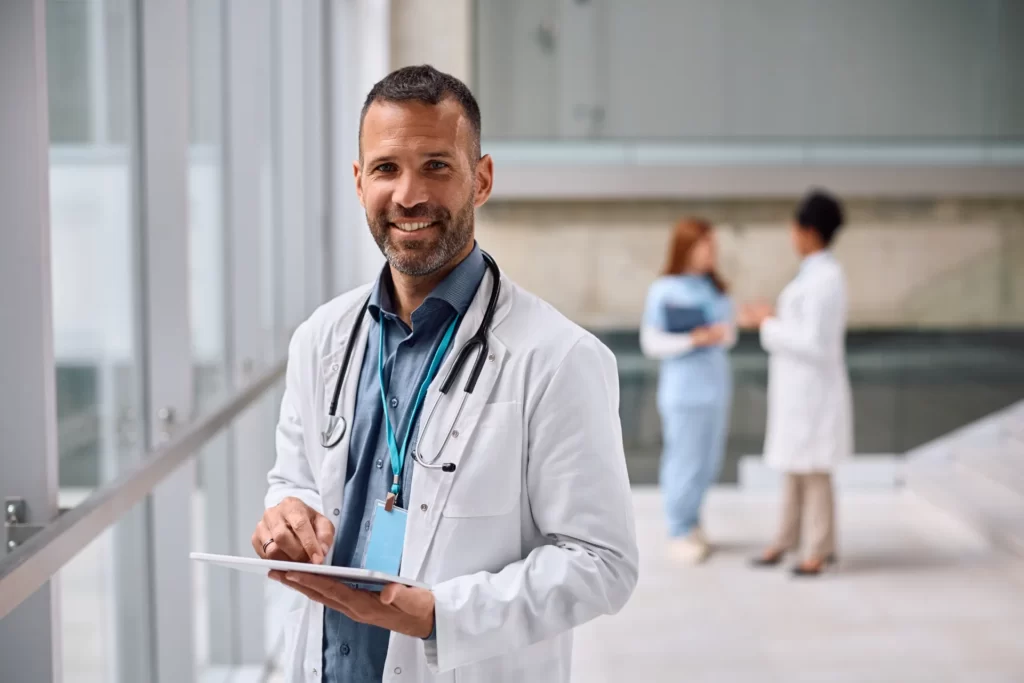 happy doctor working on digital tablet at the clin utc
